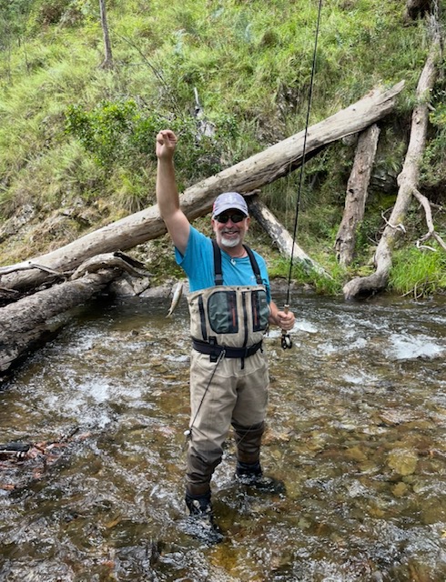Fly fishing guide standing in a shallow freestone stream